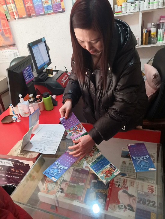 08CC  女人主一边撕着即开票，一边介绍玩法.jpg